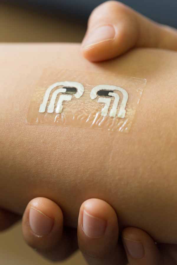 Nanoengineers at the University of California, San Diego have tested a temporary tattoo that both extracts and measures the level of glucose in the fluid in between skin cells.  The device is flexible and easy to wear.  Credit:  Jacobs School of Engineering/UC San Diego. 